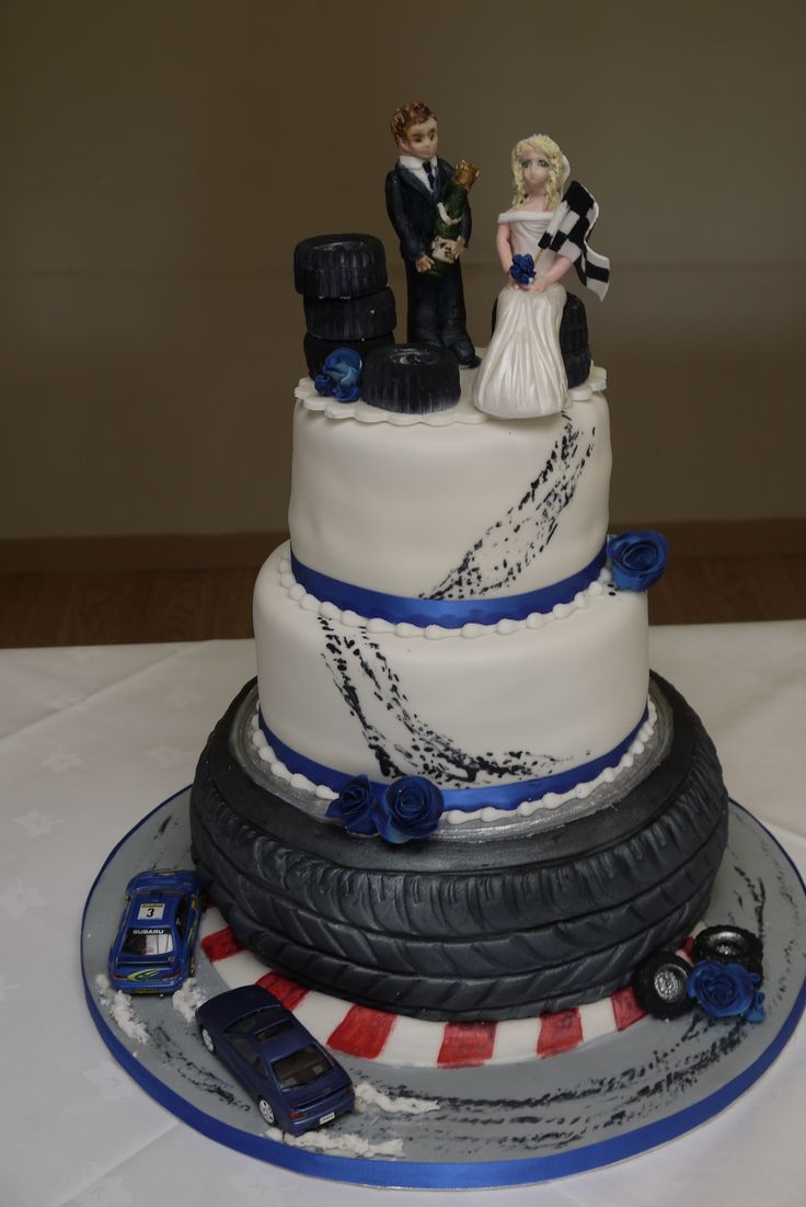 a wedding cake made to look like a tire track with a bride and groom on top