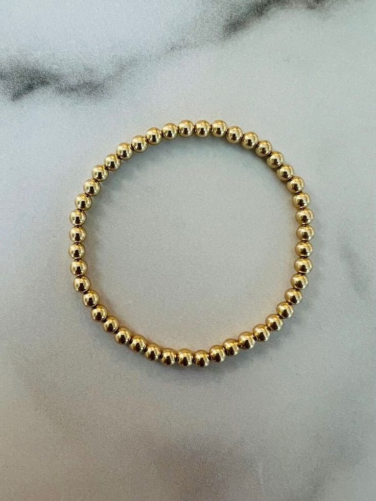 4 mm round gold-filled beads on elastic. Will not fade or tarnish.  Made to order by hand. Please reach out with any questions, including expediting orders. Please note that the sizes listed are the size of the actual bracelet, not of the wrist. Please see sizing instructions before ordering. Gold Stackable Stretch Bracelet, Classic Gold Stretch Bracelet With 8mm Beads, Yellow Gold Stackable Stretch Bracelet, Stackable Gold Stretch Bracelet, Adjustable Gold Stretch Bracelet, Stackable Round Stretch Bracelet, Dainty Round Stretch Bracelet For Everyday, Dainty Everyday Stretch Bracelet, Everyday Dainty Stretch Bracelet