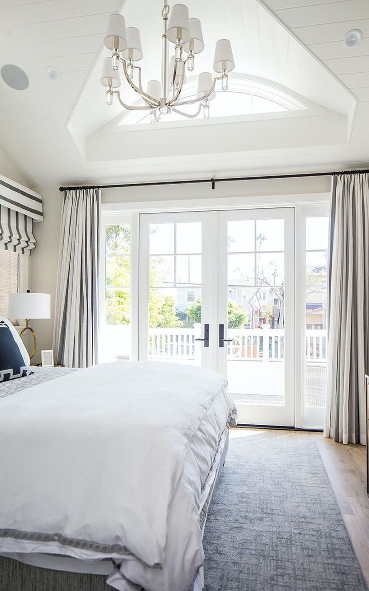 a bedroom with a large bed and french doors