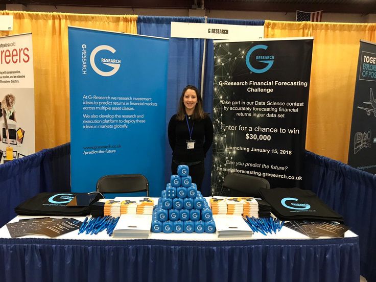 a woman standing in front of a table with blue and white items on it at a trade show