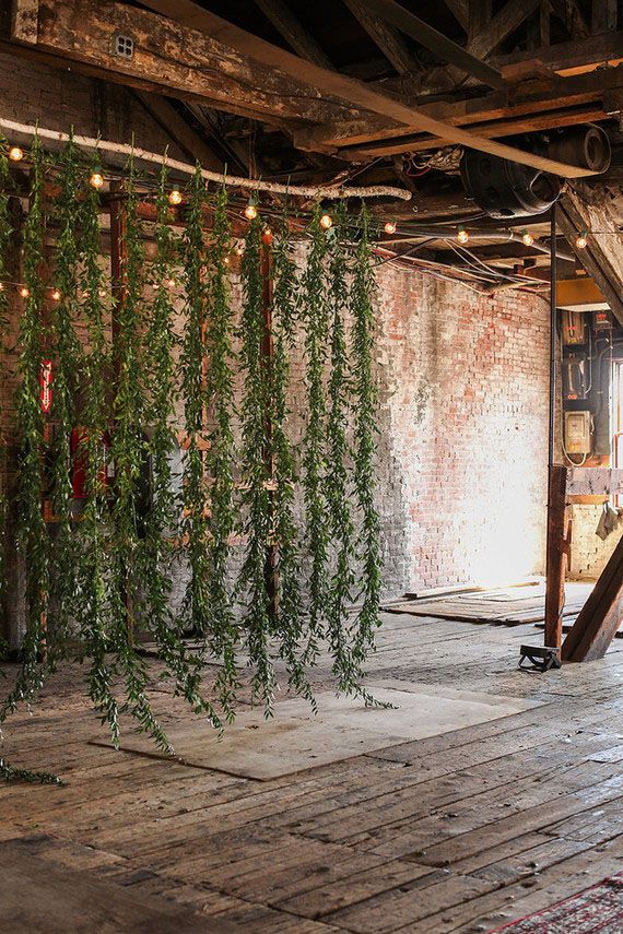 an old room with vines hanging from the ceiling and lights on the wall above it