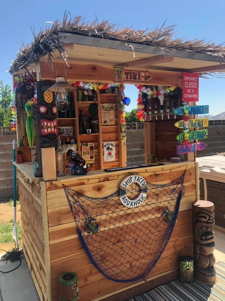 an outdoor bar with lots of items on it's roof and shelves in the background