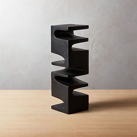 a black sculpture sitting on top of a wooden table