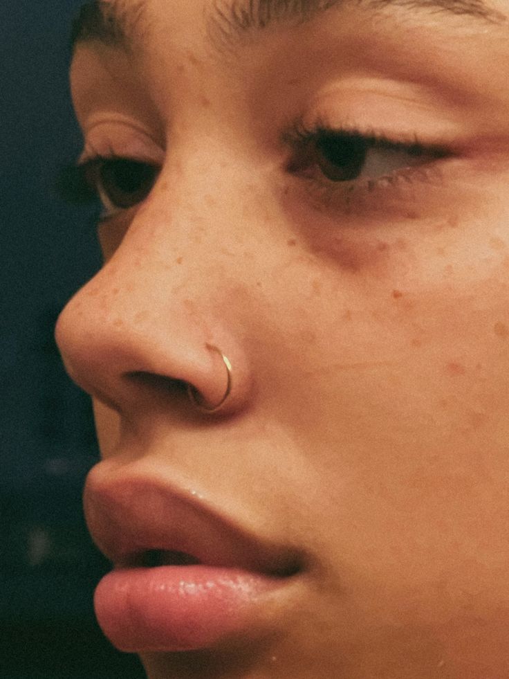 a close up of a person with piercings on their nose and nose ring in front of them