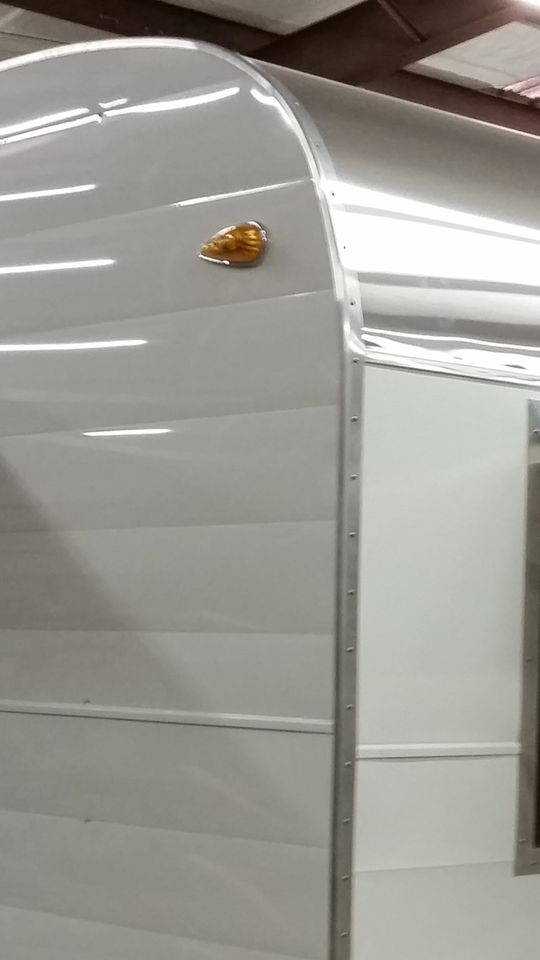 a white trailer parked in a garage next to a wall with a door on it