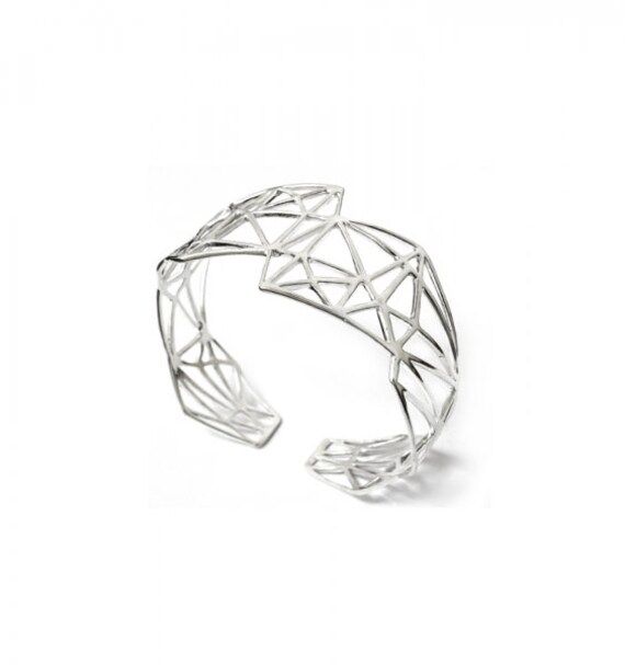 Eexquisite Geometric Silver Bracelet that boasts a unique geometric design, showcasing exceptional artistry and attention to detail. Made from silver, it combines elegance and durability for a timeless accessory. Specifications: Material: Silver 925 Width: 25 - 48 mm Weight: 21 g Suitable Wrist Size: 17 - 20 cm Why You'll Love It: The Geometric Silver Bracelet is perfect for those who appreciate unique, high-quality jewelry. Its bold design and superior craftsmanship make it a standout piece, id Modern Sterling Silver Bracelet For Formal Occasions, Modern White Gold Metal Cuff Bracelet, Modern White Gold Jewelry With Unique Design, Elegant Sterling Silver Geometric Jewelry, Elegant Geometric Sterling Silver Jewelry, Modern Silver Bangle Bracelet, Modern Silver Bangle For Formal Occasions, Modern Metal Cuff Bracelet For Formal Occasions, Modern Formal Bangle Bracelet