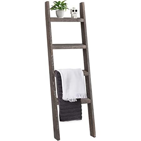 a wooden ladder shelf with towel and potted plant