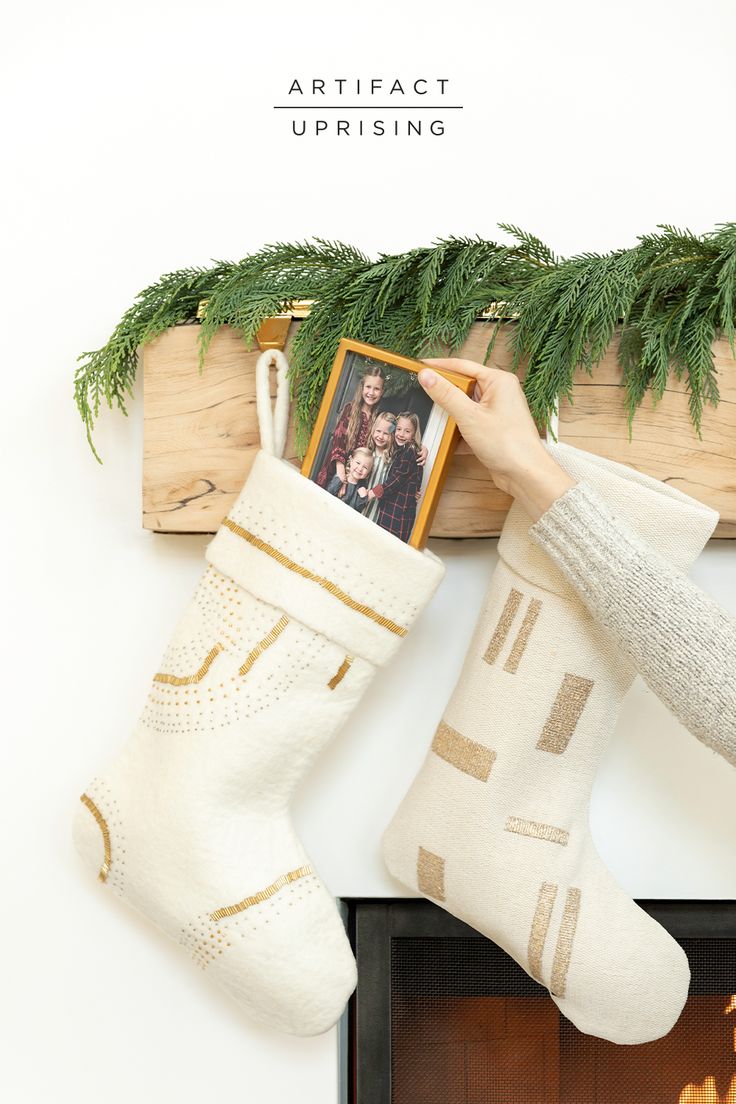 a person holding a christmas stocking over a fireplace