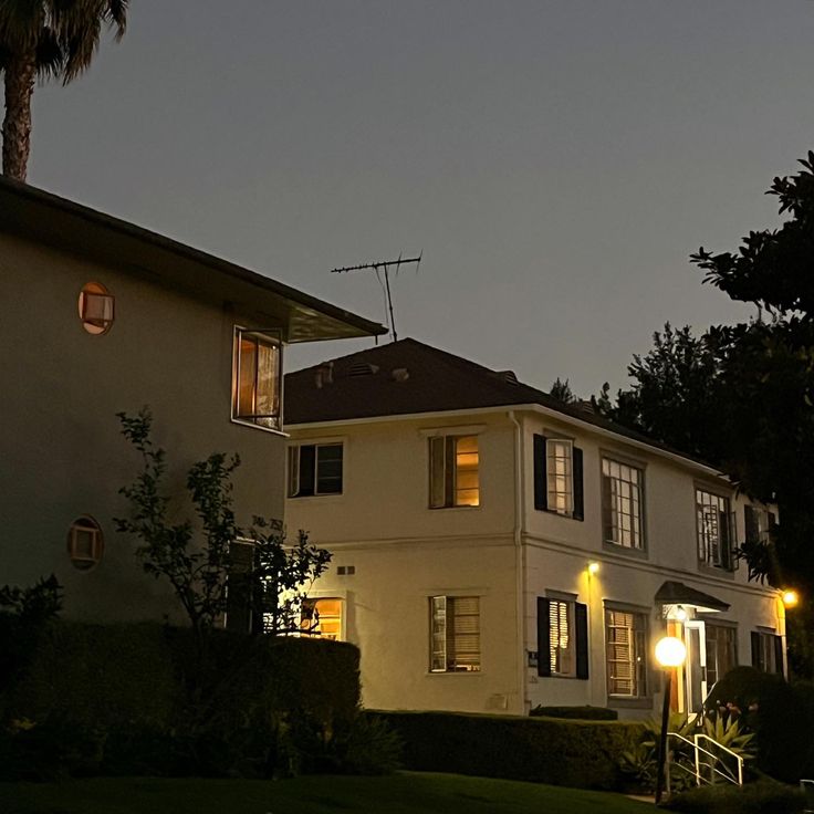 a large white house with lights on at night