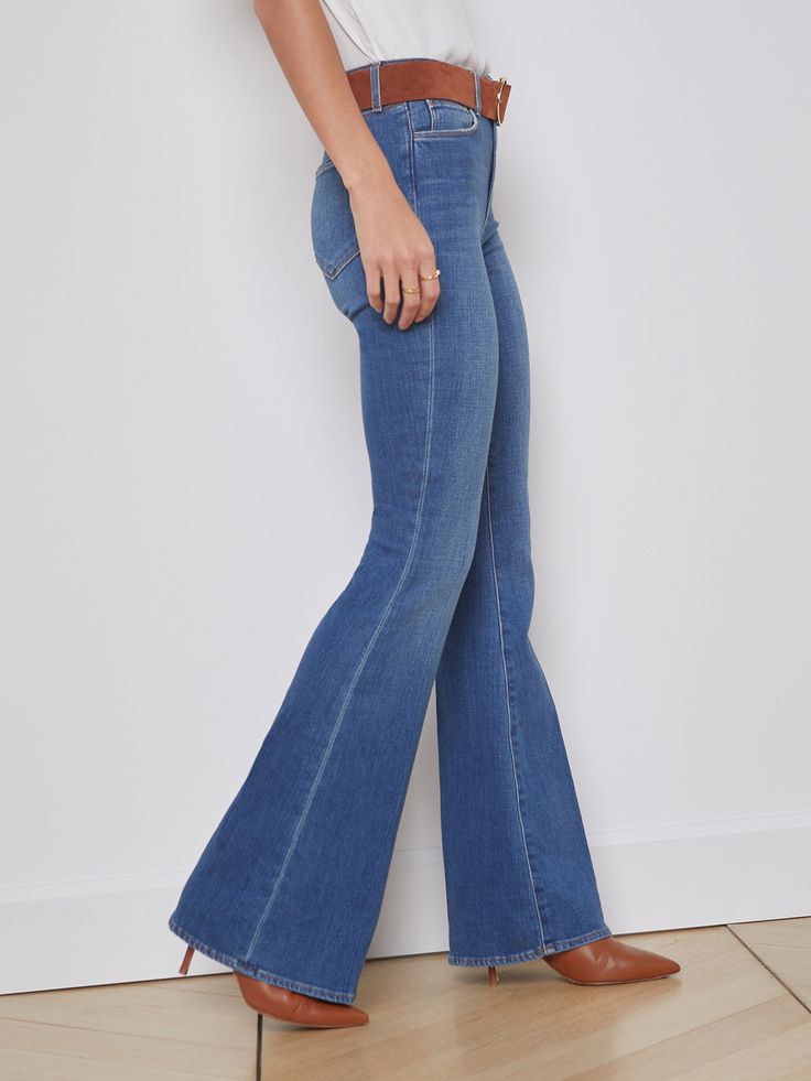 A vintage-inspired bell-bottom jean in medium blue with classic fading and whiskering. Premium stretch denim in a light blue hue has a contoured waistband that fits securely around the natural waist as it smooths and slims, while the premium stretch denim hugs hip, thigh, and fitted through the knee before releasing into a sleek straight leg which can be altered up to 4" without drastically changing the shape. | L'AGENCE Bell Jean In Authentique Classic Blue Flare Jeans, Fitted Flare Jeans In Medium Wash, Medium Wash Denim Flares With Flared Hem, Medium Wash Denim Jeans With Flared Hem, Classic Flare Jeans In Denim Blue, Medium Wash Fitted Mid-rise Flares, Classic Flare Denim Bottoms, Classic Flared Denim Bottoms, Classic Denim Blue Flare Jeans