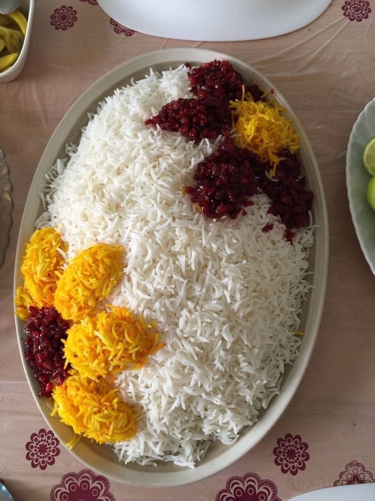 rice and other food on a plate with fruit in the bowl next to it,