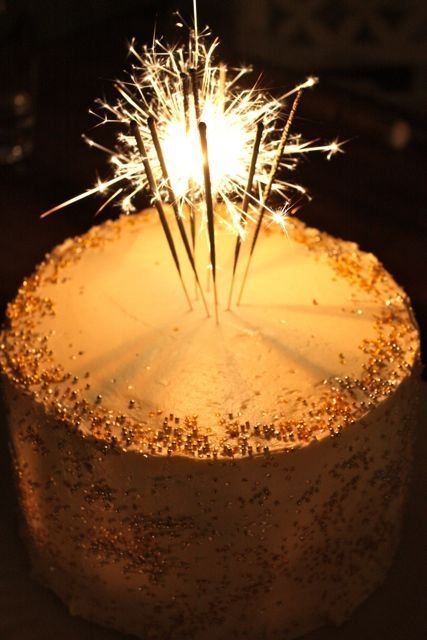 a cake with sparklers on it sitting on a table