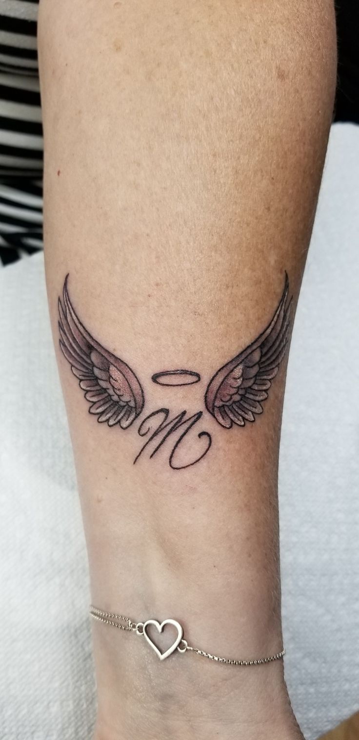 a woman's foot with an angel wing tattoo on the side of her leg