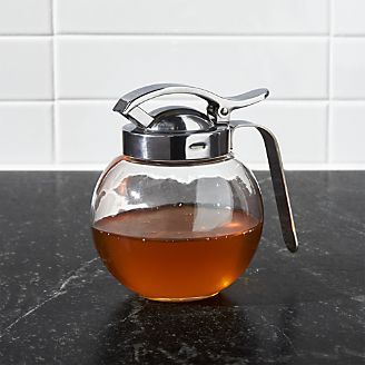 a glass tea pot filled with liquid on top of a counter