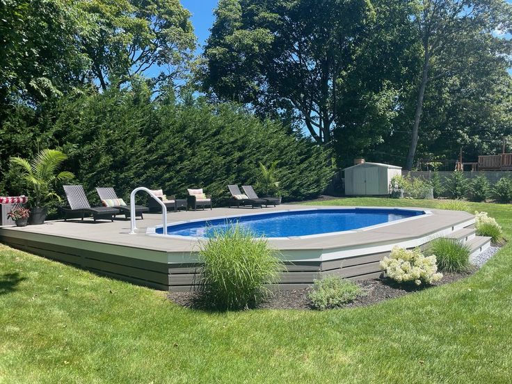 a backyard with a swimming pool surrounded by lush green grass