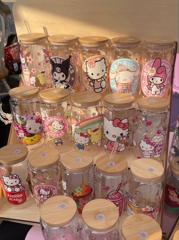 many hello kitty tumblers are on display together