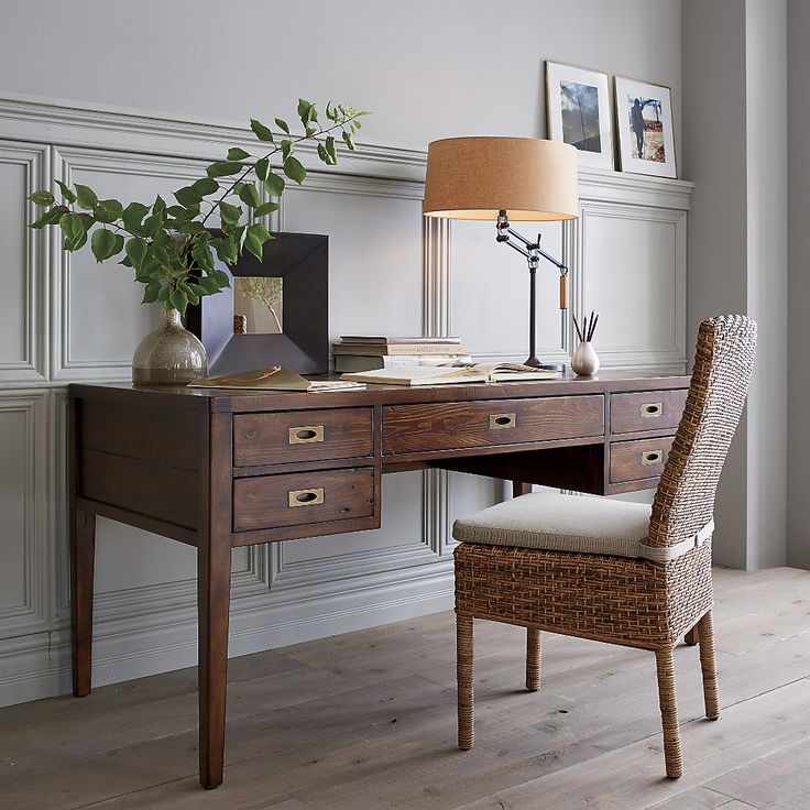 a desk with a chair, lamp and pictures on the wall