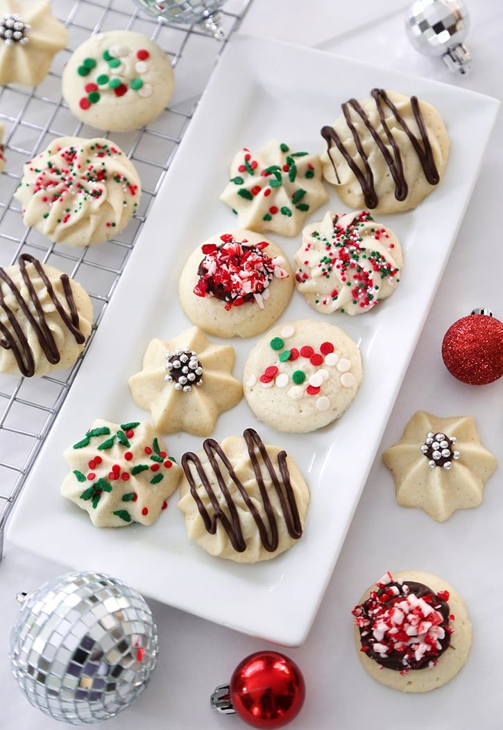 decorated cookies on a white plate next to christmas decorations