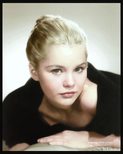 a woman with blonde hair and blue eyes posing for a photo