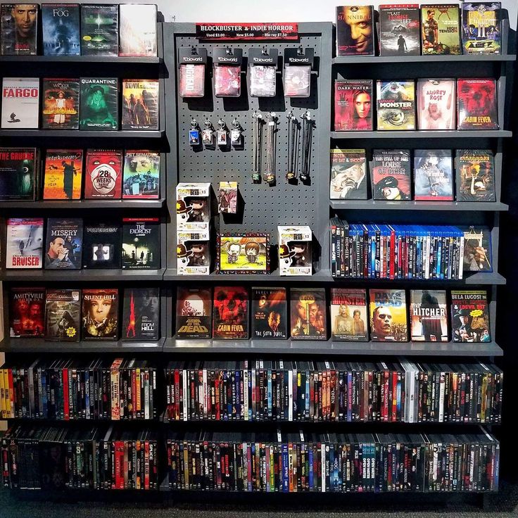 there are many movies on the shelves in this room