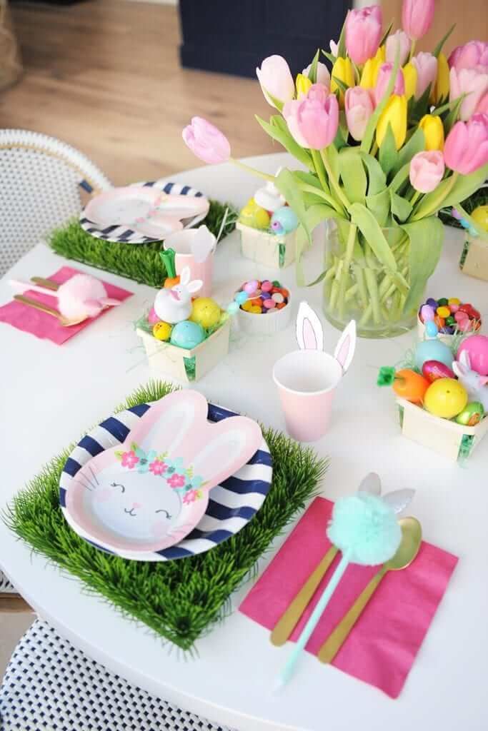 a table set for easter with bunny napkins and flowers