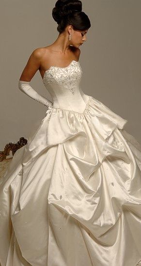 a woman in a white wedding dress is posing for the camera