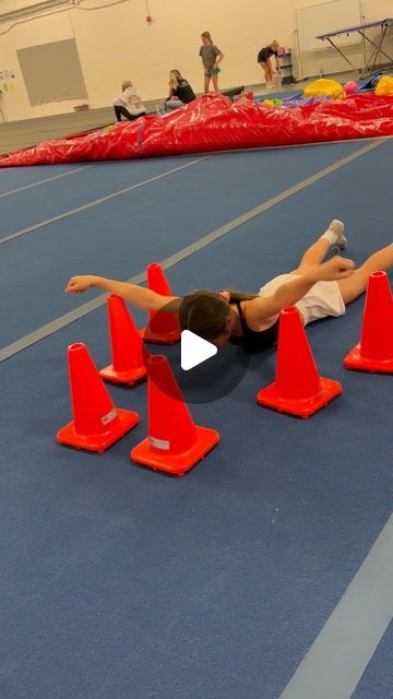 a woman laying on the ground surrounded by orange cones