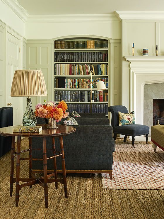 a living room filled with furniture and a fire place in front of a book shelf