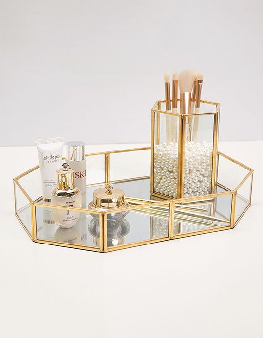 a set of three mirrored trays with bottles and containers in them on a white surface