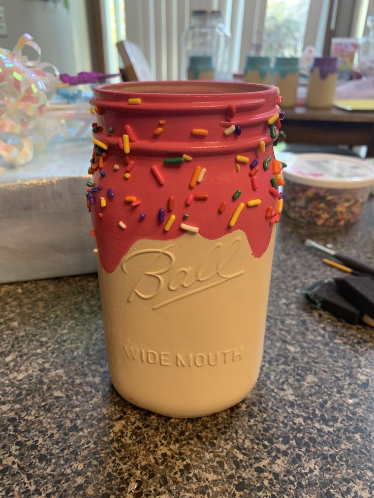 a cup with sprinkles on it sitting on a counter