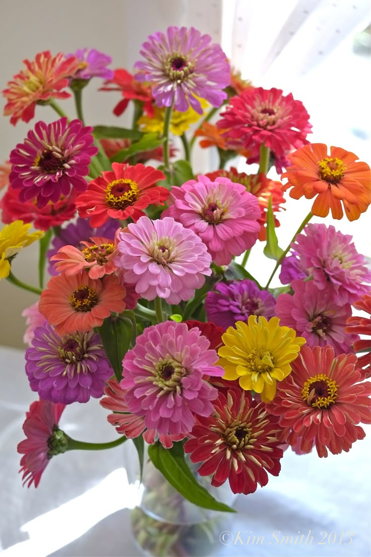 a vase filled with lots of colorful flowers