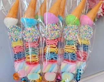 a bunch of ice cream cones with sprinkles on them in plastic bags