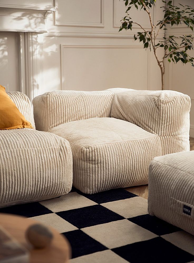 a living room with two couches and a checkerboard rug on the floor