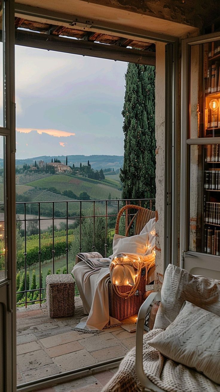 an open window with a view of the rolling hills and countryside in the distance at dusk