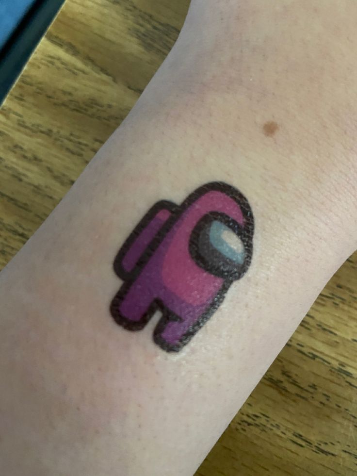 a person with a tattoo on their arm has a pink object in the shape of an elephant