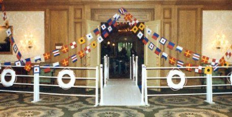 an entrance to a building with flags on the railings and carpeted flooring