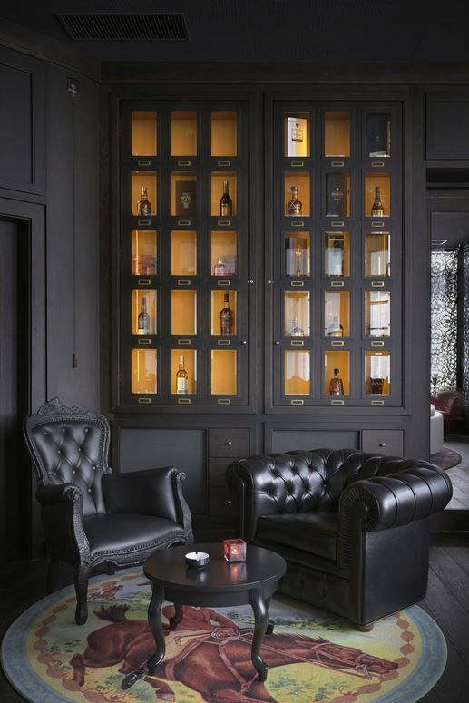 a living room filled with black furniture and lots of shelves