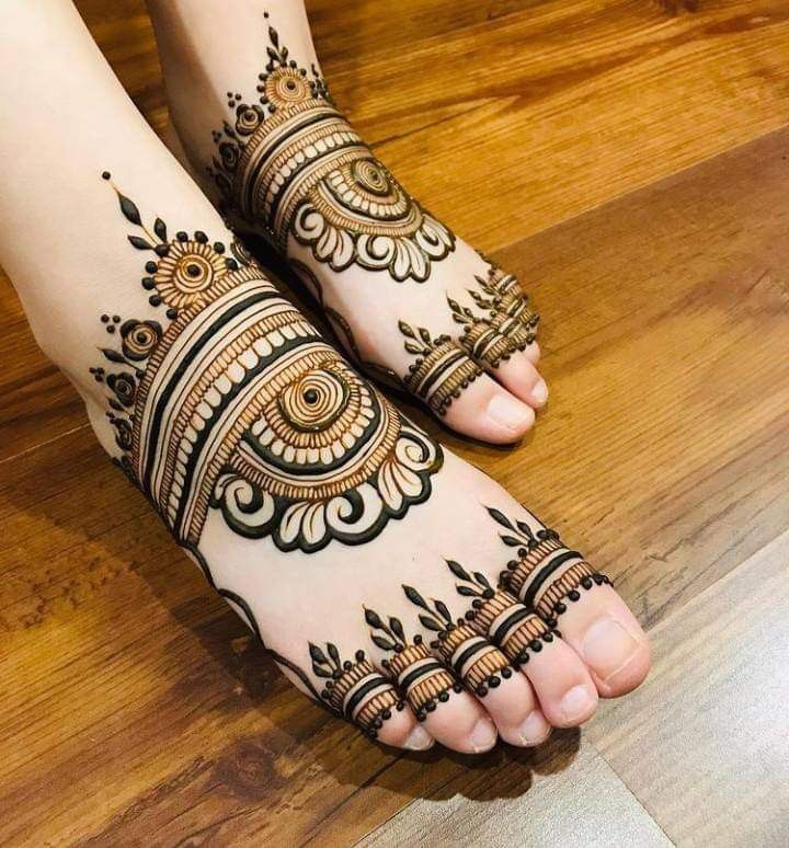 the feet are decorated with henna and intricate designs on it's legs, which is