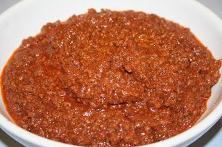 a white bowl filled with chili sauce on top of a table