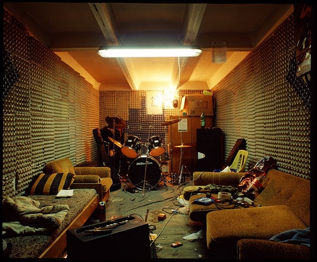 a living room filled with lots of furniture and musical instruments