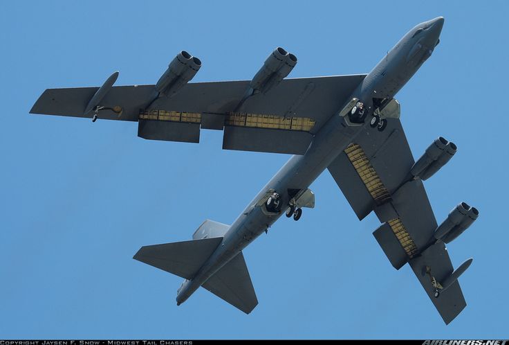 an airplane flying in the sky with its landing gear down