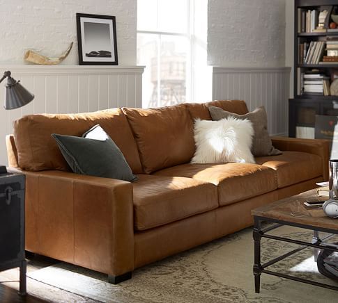 a living room filled with furniture and a lamp on top of a table in front of a window