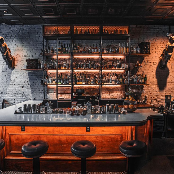 a bar with stools and shelves filled with bottles