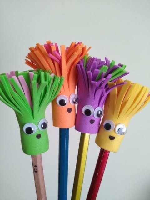 four different colored pencils with googly eyes and hair sticks sticking out of them