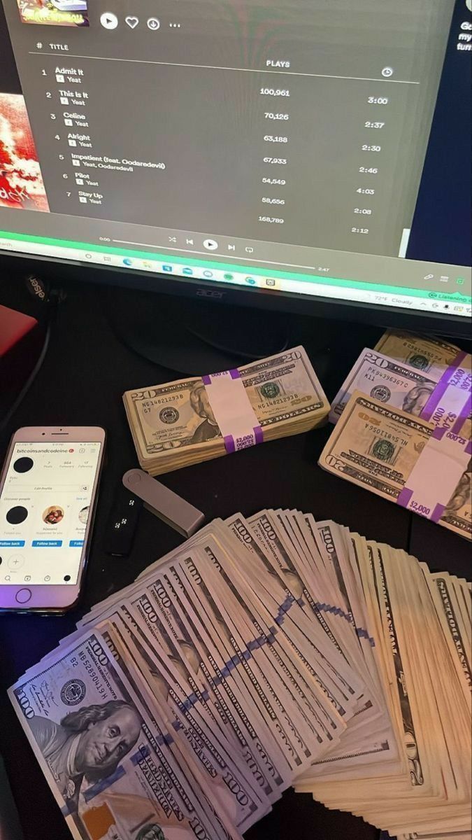 stacks of money sitting in front of a computer screen