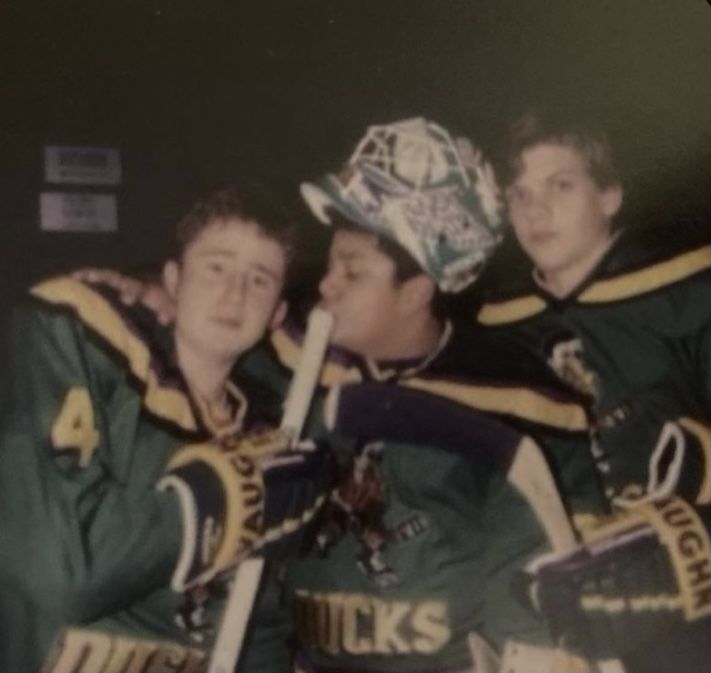 three hockey players are hugging each other and posing for a photo in front of the camera