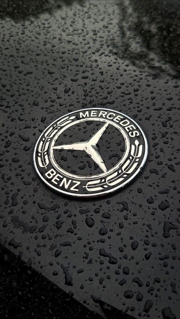 the mercedes logo is shown on a wet surface