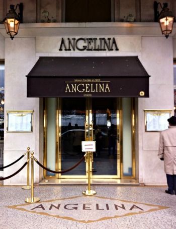 the front entrance to an angelina store with gold trimming and black awnings