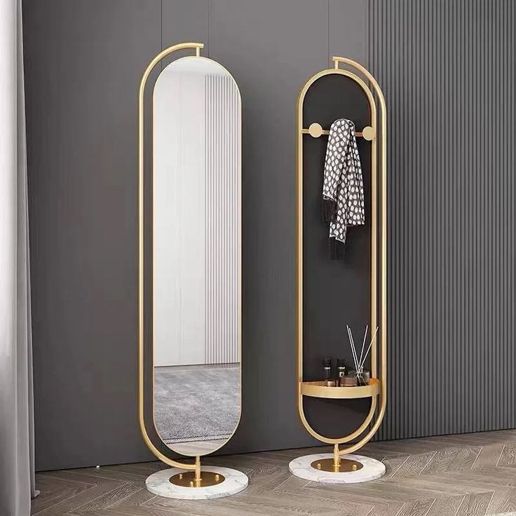 an oval mirror sitting on top of a wooden floor next to a shelf with a coat rack