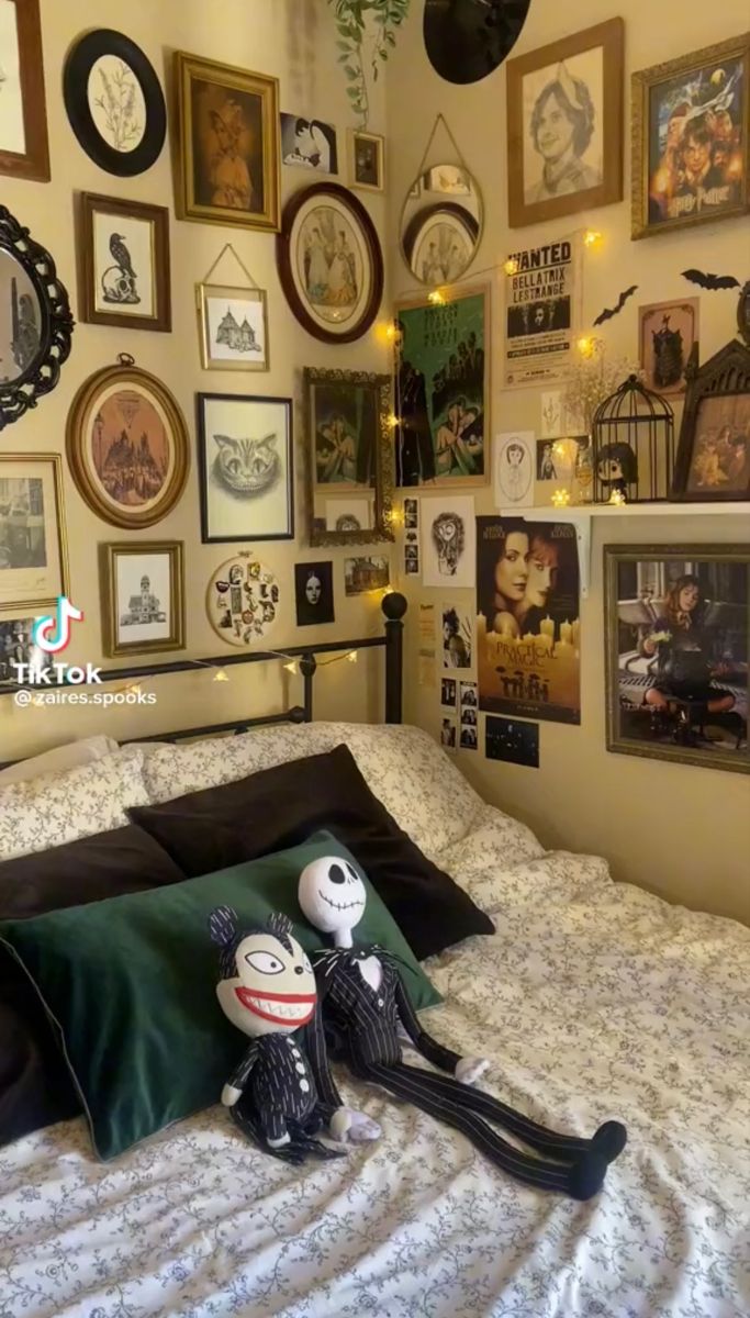 a bed with lots of pictures on the wall above it and two stuffed animals sitting on top